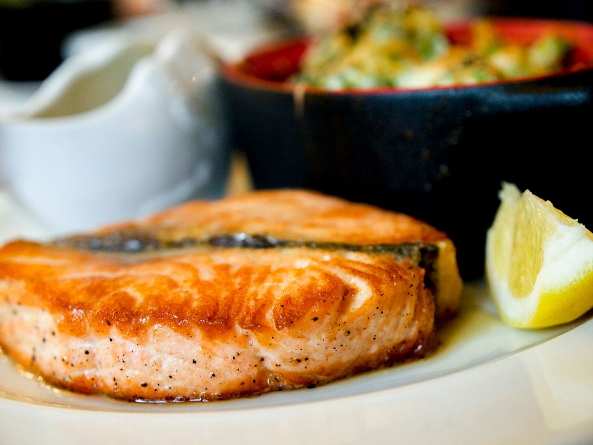 A seared fish fillet with a lemon wedge